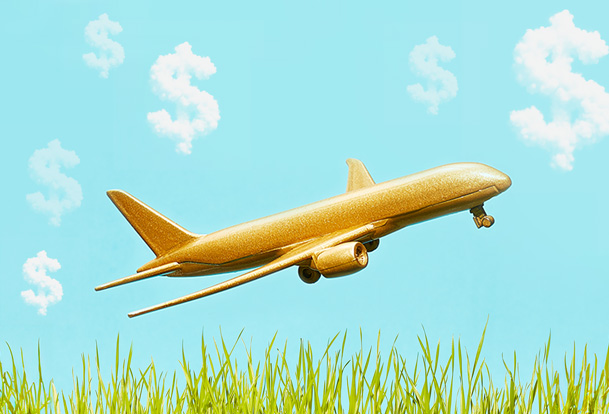 Gold airplane and clouds forming dollar signs