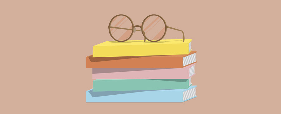 Reading glasses sitting on top of a stack of books.