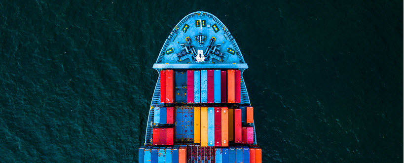 Vue en plongée d'un bateau rempli de conteneurs.