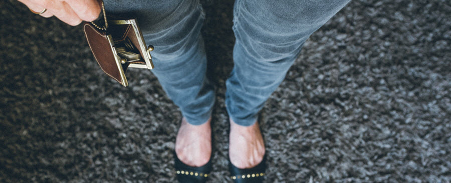 bird's eye view of woman wearing skinny jeans and holding a vintage coin purse