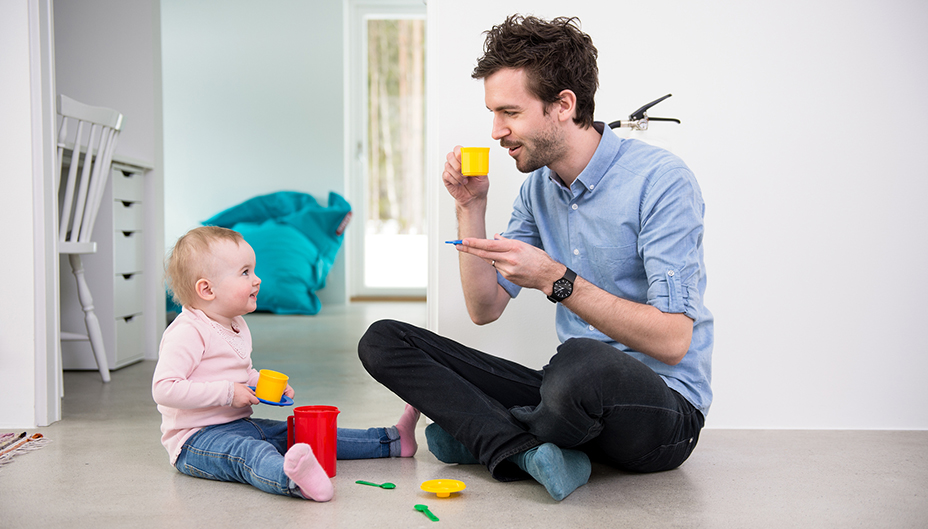 Photo d’un père et de sa fille faisant semblant de boire du thé. 