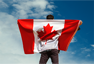 Image d’un homme debout portant le drapeau canadien sur son dos