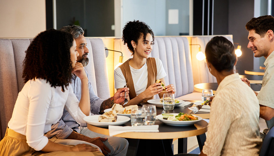 A group discusses investing lessons around a restaurant table.