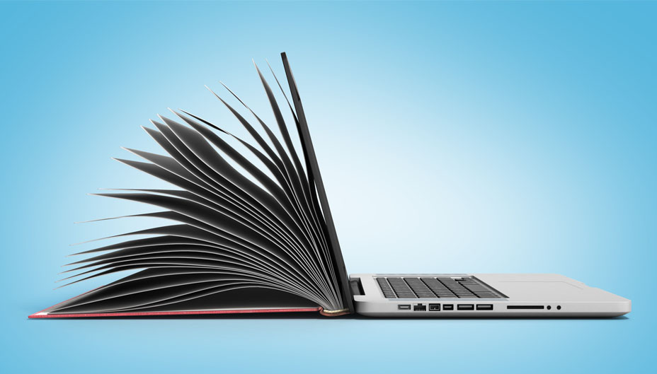 An open book leaning against an open laptop.