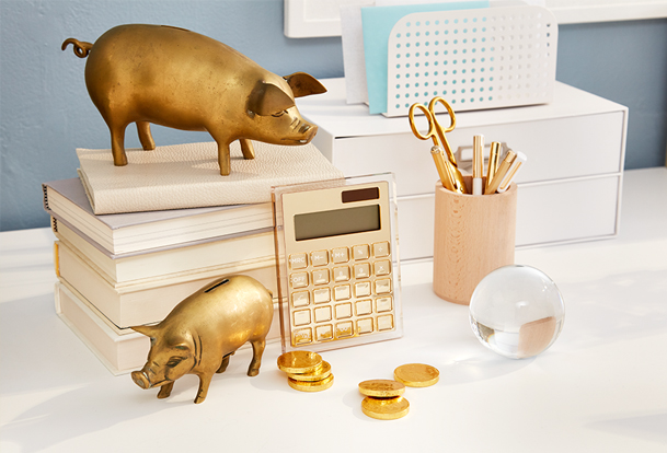 Some decorative pigs are shown on a home office desk.