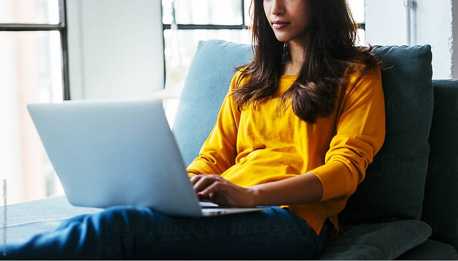 A woman views a laptop.