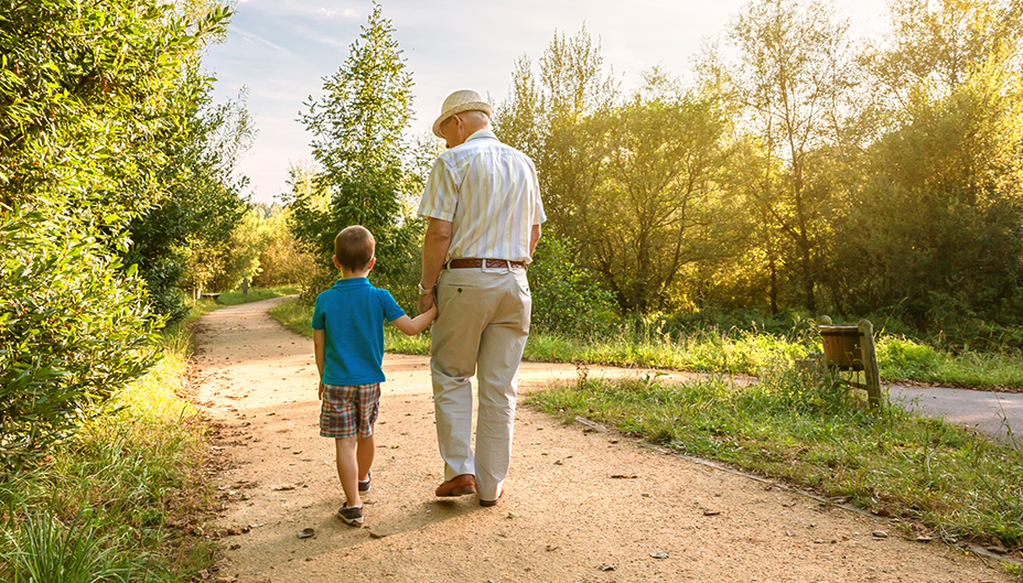 A child walking with his grandpa in the nature.