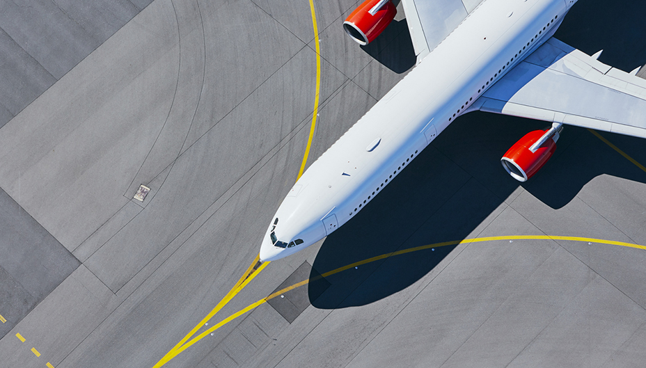 Aerial view of airplane taxiing on a runway.