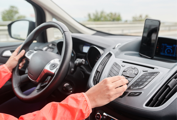 Someone adjusting their car dashboard