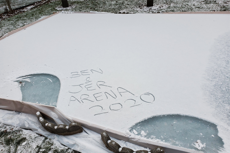 A hockey rink being built has, "BEN & JER ARENA 2020" written on it in the snow.