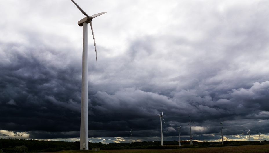 A photo of wind turbines during a cloudy day.