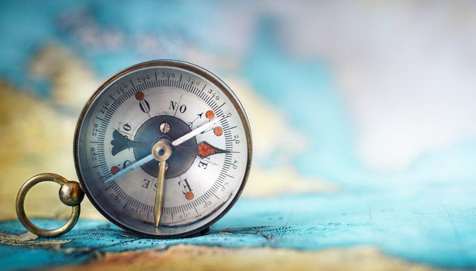A compass rests on a map.