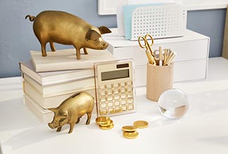 Golden pigs placed on orginized desk.