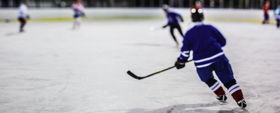 Back view of a person playing hockey in an ice rink