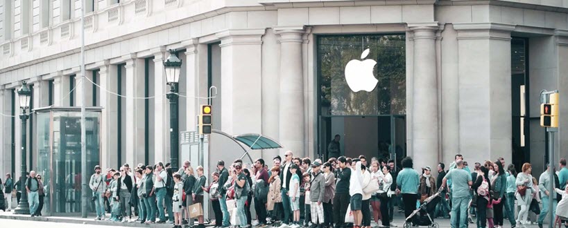 Des gens font la file devant une boutique Apple.