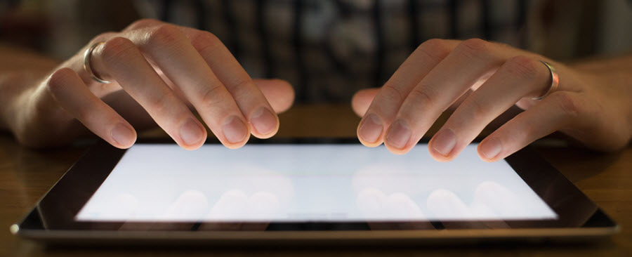 Close-up of a person's fingers as they use their tablet