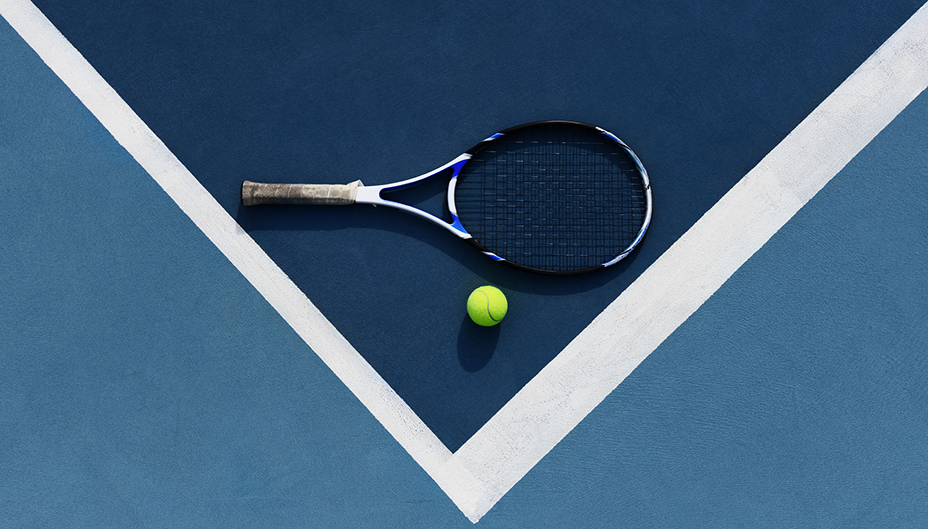 Bird's eye view of tennis racket and ball on a tennis court. 